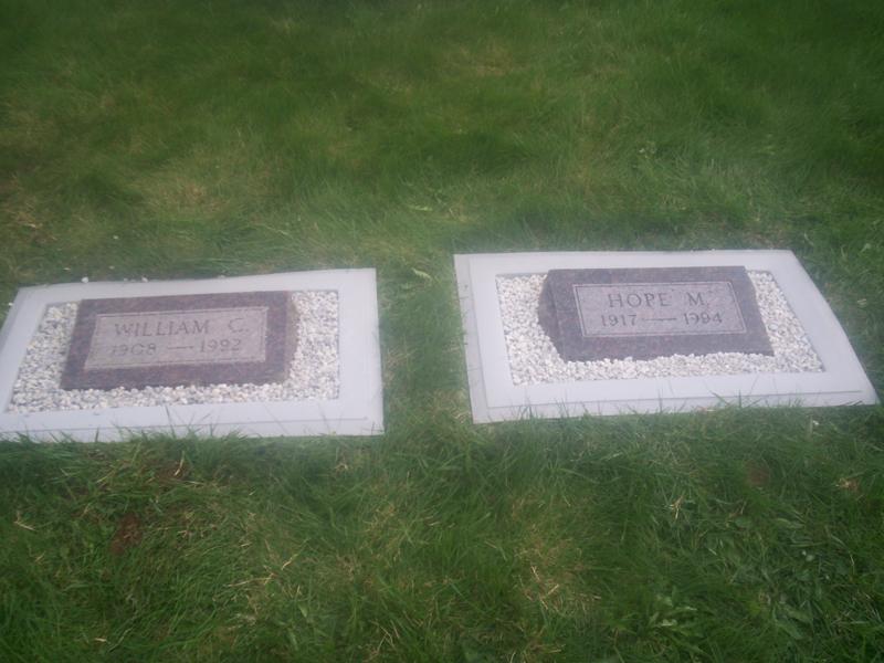 A granite bevel marker with an engraved inscription, installed level with the surrounding grass.