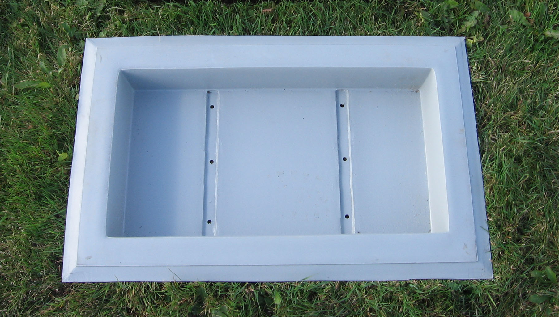 A Grave Saver foundation recessed into the ground, ready for a marker to be set inside it.