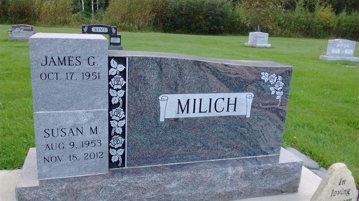 A gray and blue granite cremation urn monument with rose engraving and a tall side panel of names and dates.